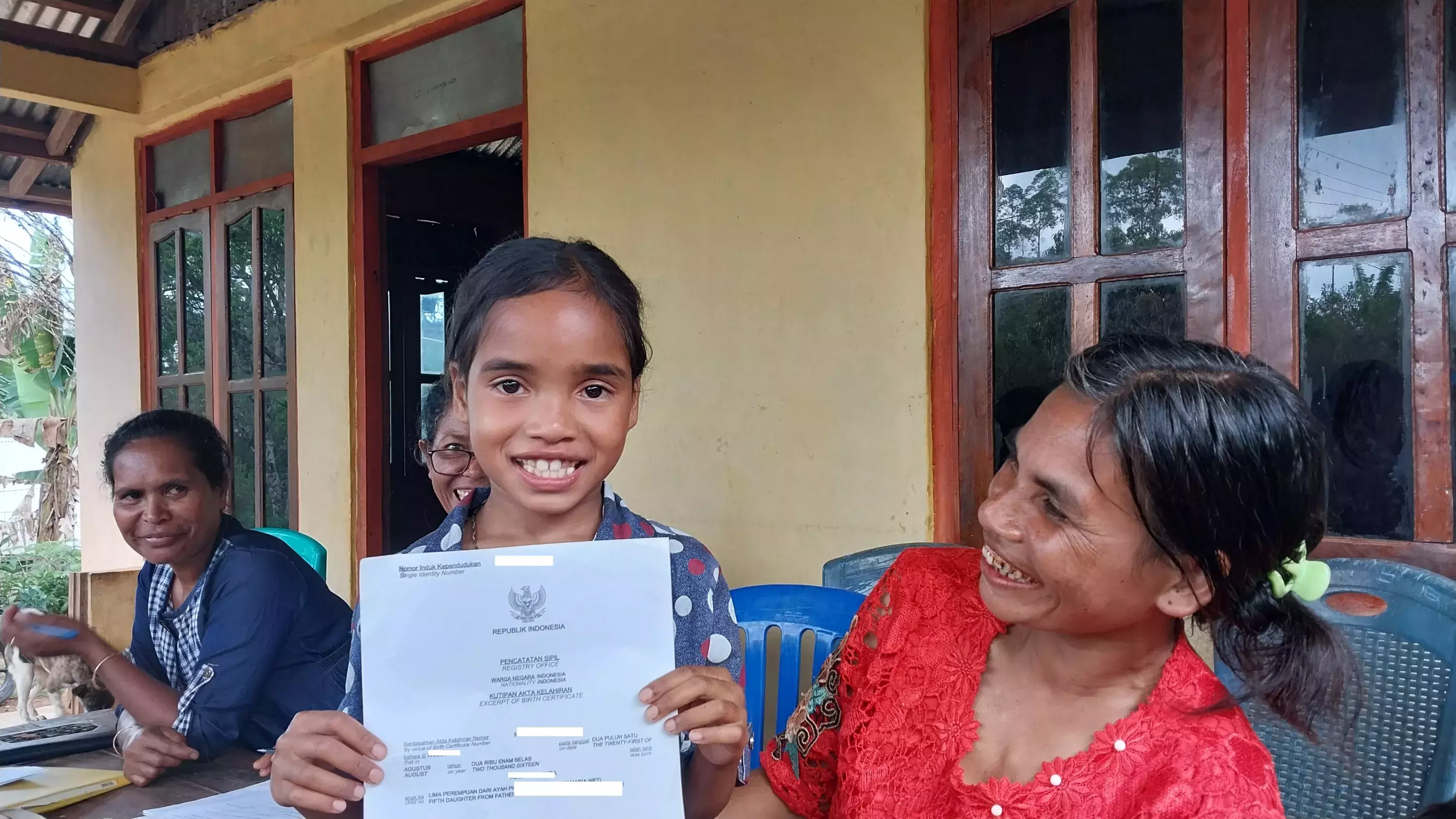 child from ende indonesia holding out a certificate