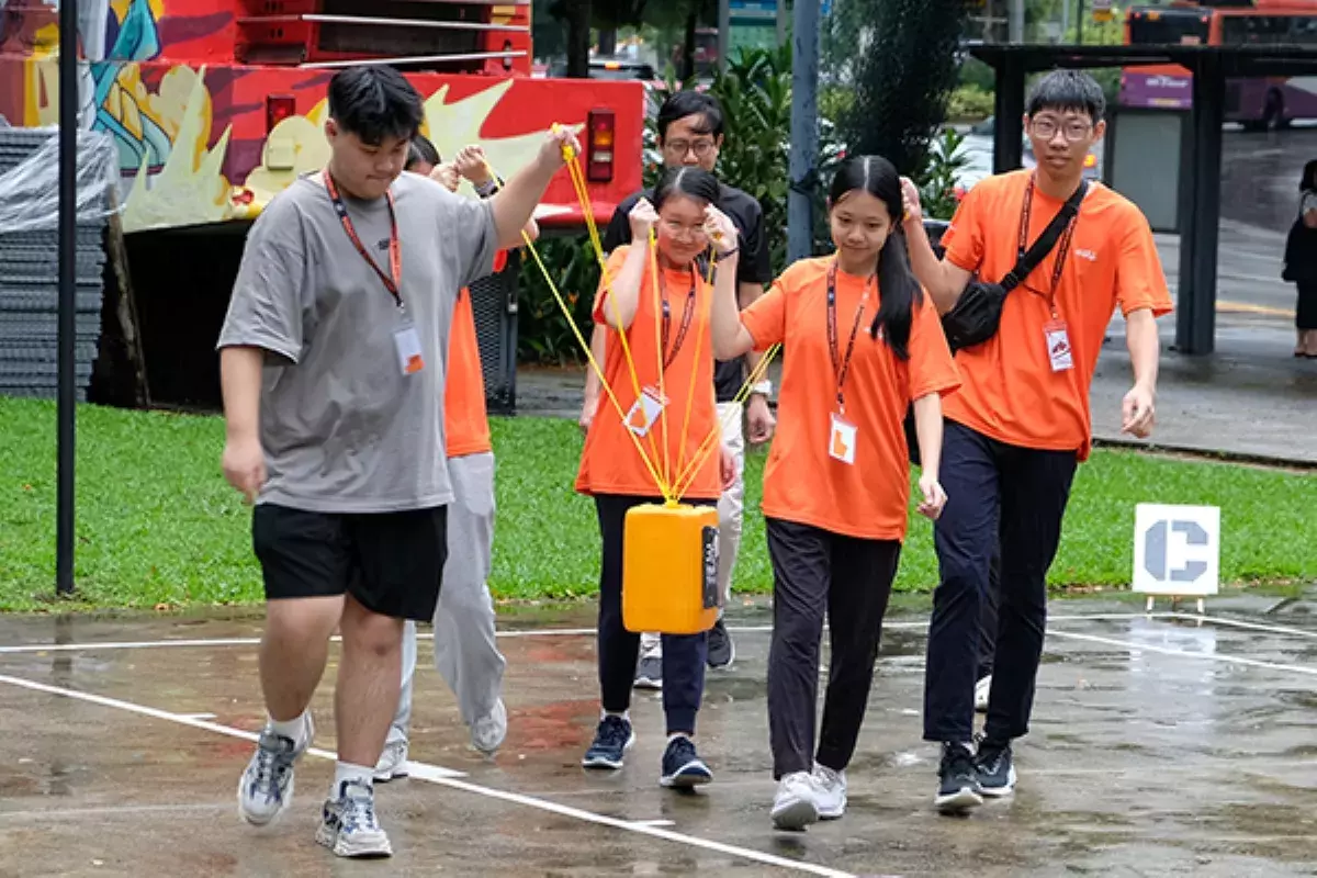 A group of people wearing matching orange shirts participating in an outdoor activity.