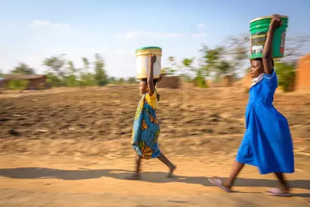 2 women with basin of water in their head