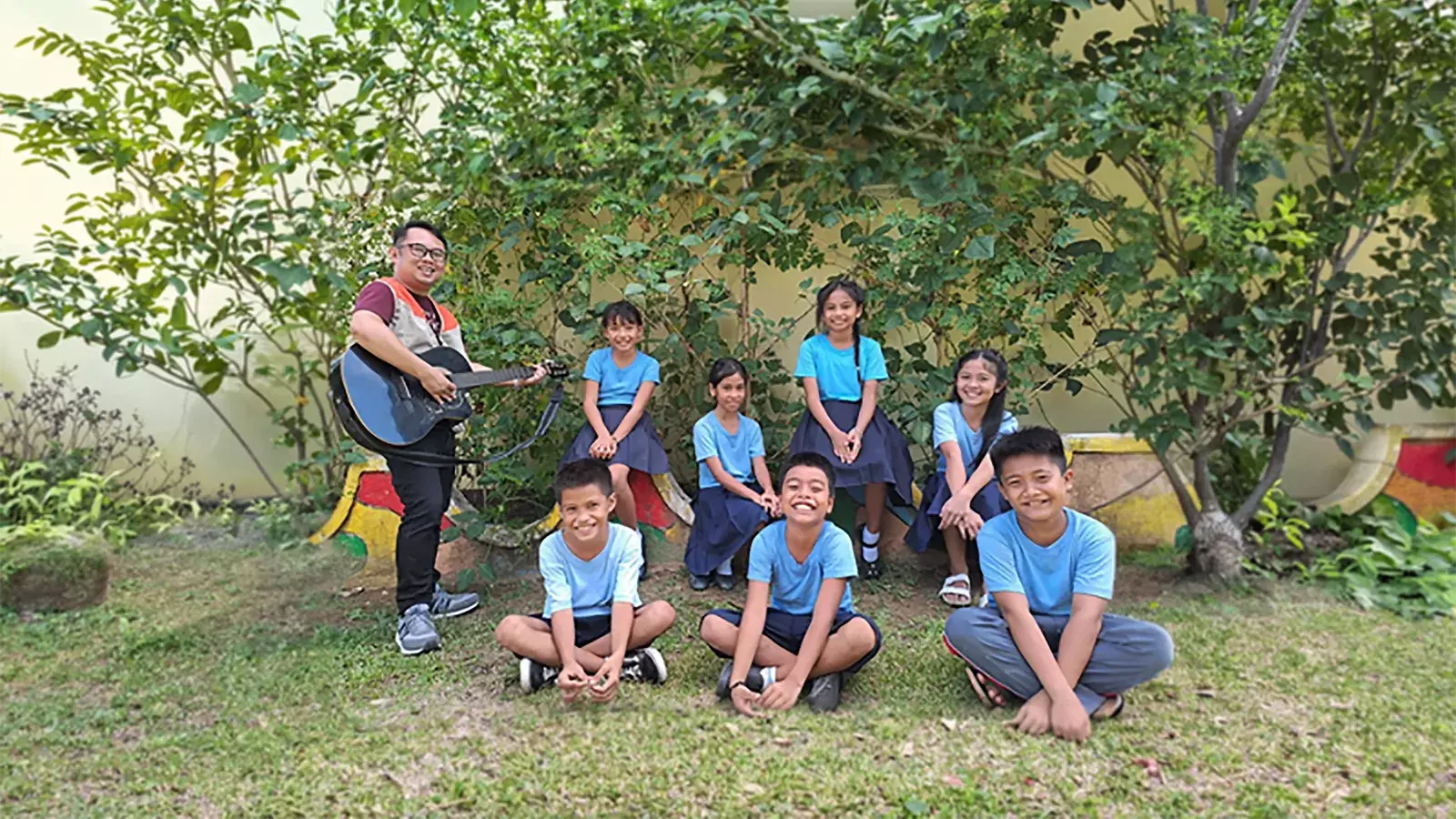  World Vision Staff playing guitar with children in Bohol Philippines