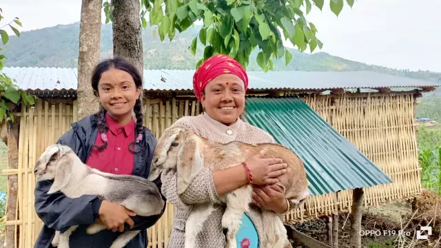  mother and child holding out goats for livelihood
