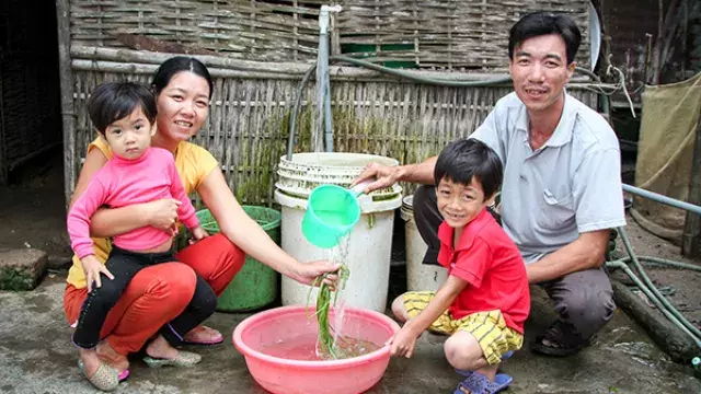 Family with children using water basin outdoors