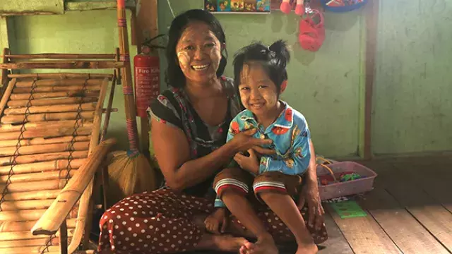 Adult and child with tanaka sitting in modest room