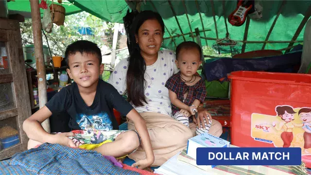 Family in bamboo shelter with containers and dollar match box