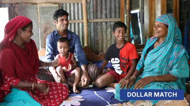 Family with children sitting indoors on bed with dollar match label